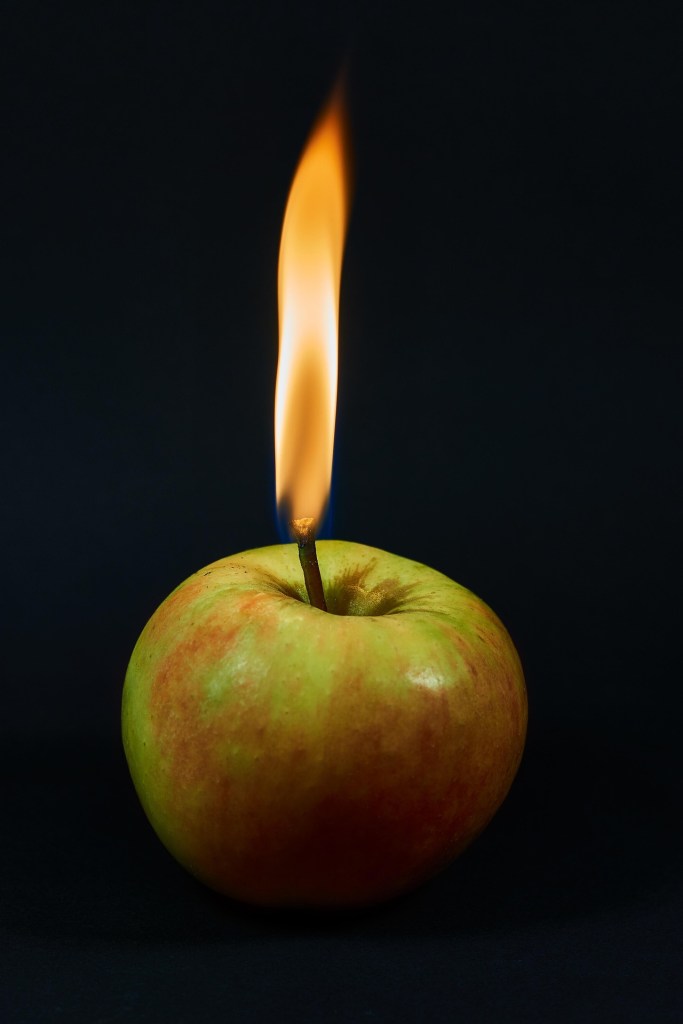 A flame burning on an apple